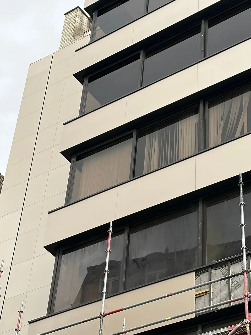 Façade d'immeuble en ville, montée sur échafaudage.